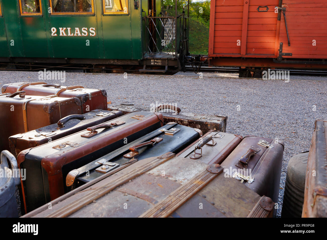Assurance avec des valises en face d'un vieux train avec un wagon et une deuxième classe verte passanger wagon. Banque D'Images