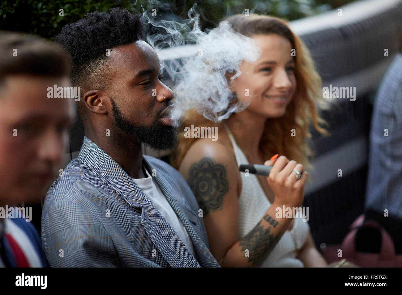 Les gens qui fument à l'aide de vape happing pens à Manchester Banque D'Images