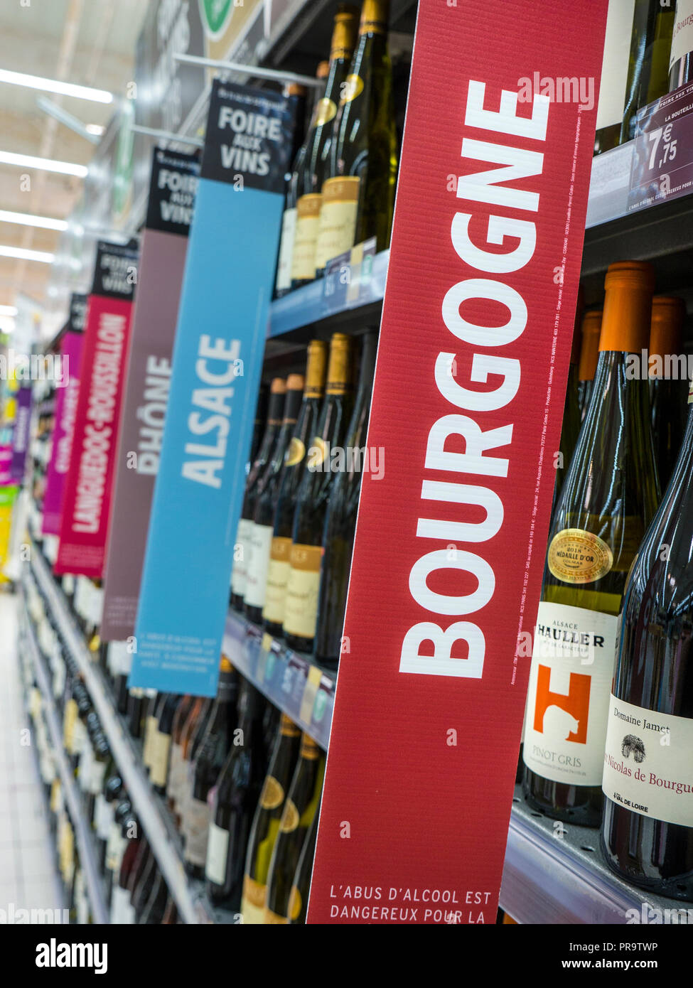 Vin Français supermarché allée avec BOURGOGNE bannière promotionnelle afficher en premier plan avec d'autres variétés de bannière vin derrière la Bretagne France Banque D'Images