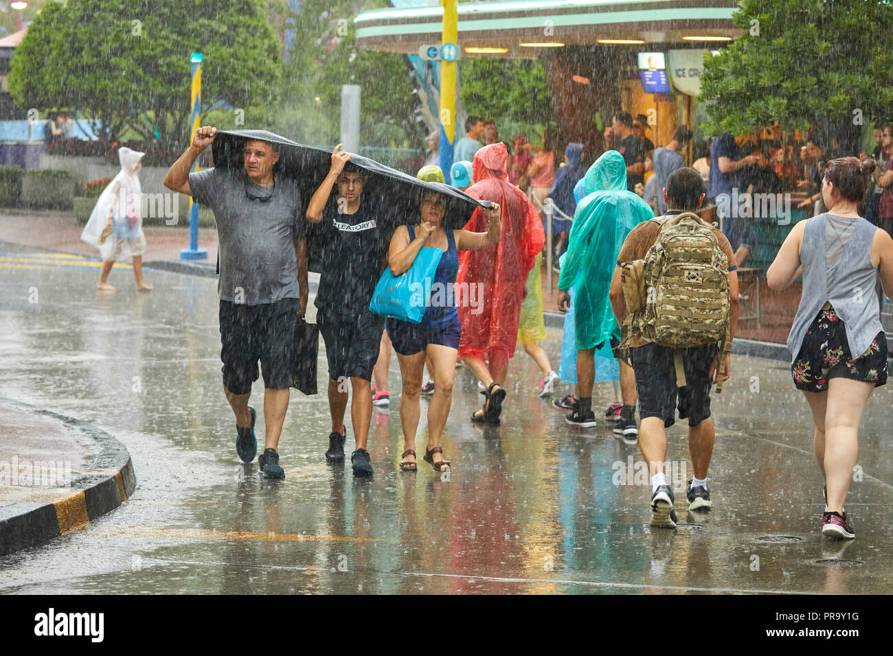 Tourist dans la pluie à Universal Studios Orlando en Floride Banque D'Images