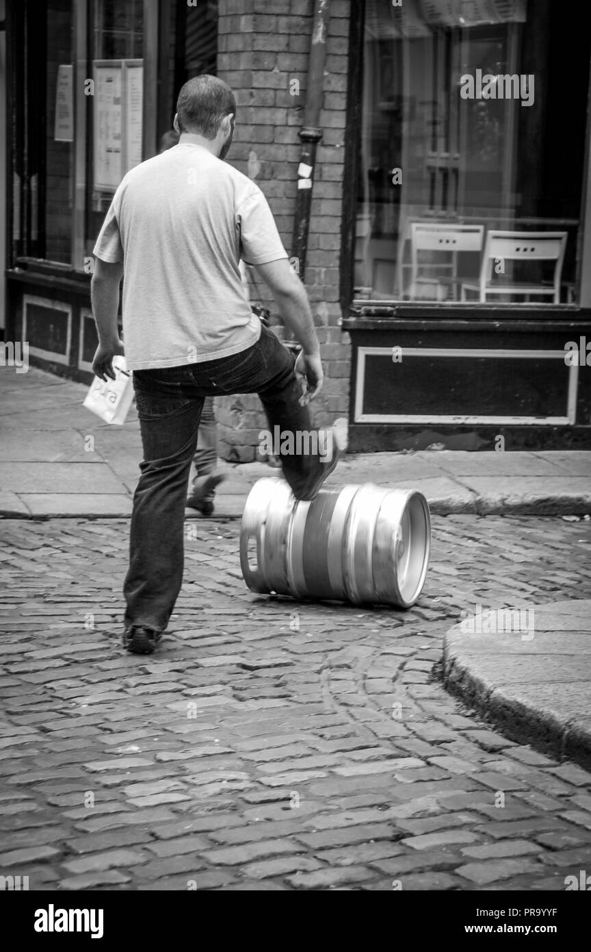 Homme poussant un baril de bière Banque D'Images