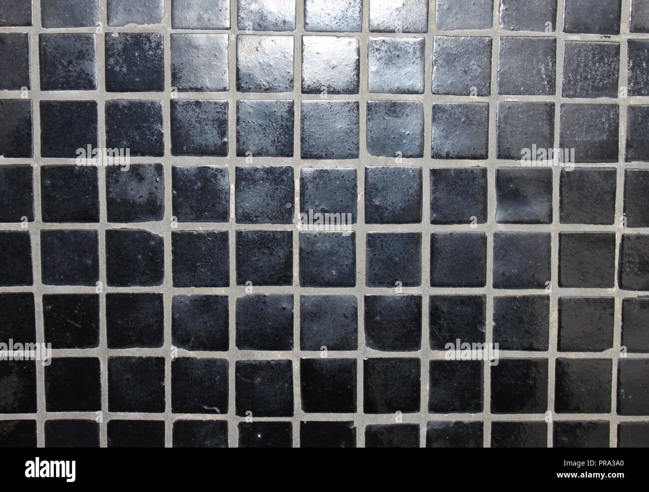 Carreaux de mosaïque noire sur un mur Banque D'Images