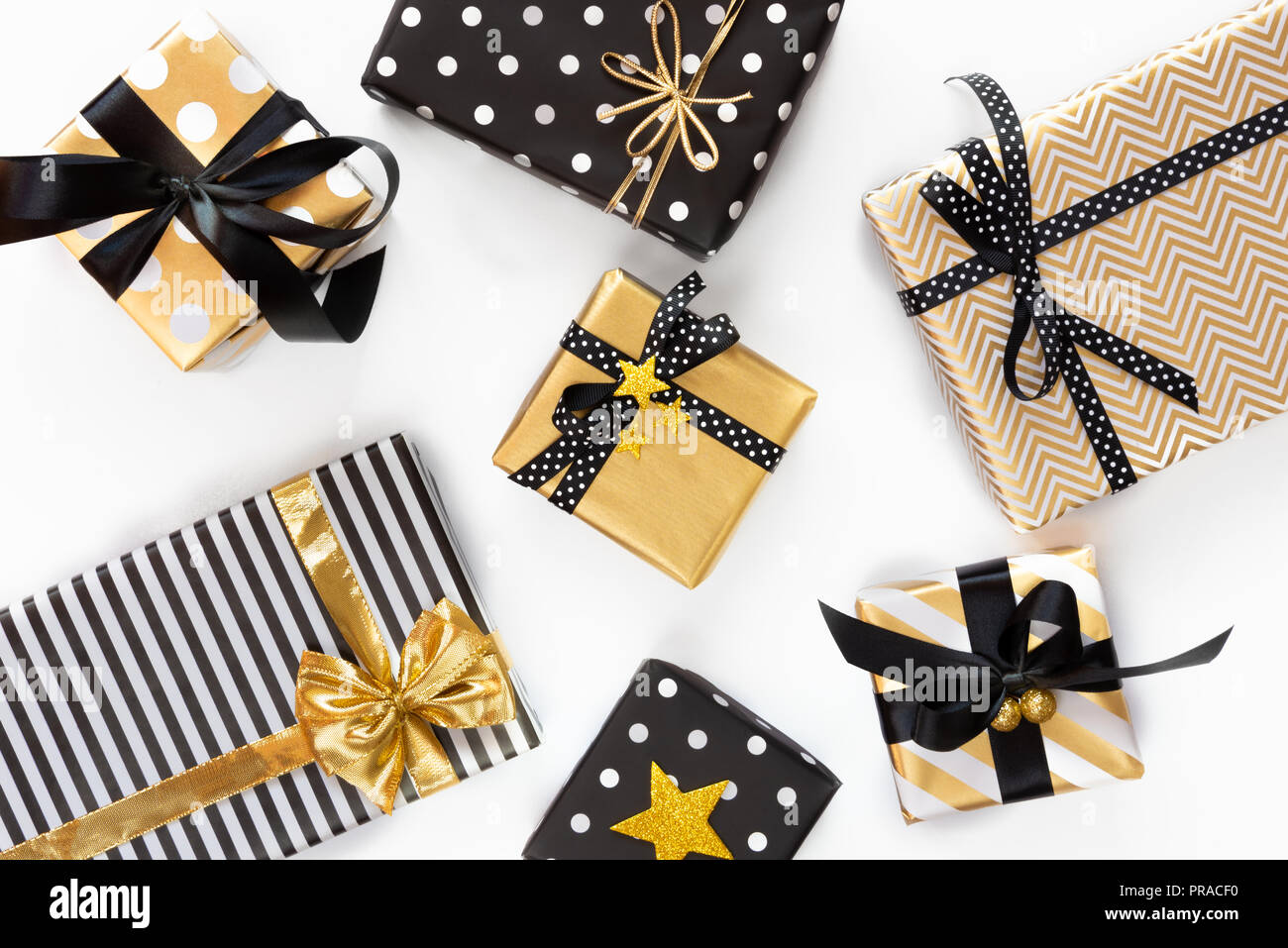 Vue de dessus de boîtes-cadeaux dans différents coloris noir, blanc et doré. Mise à plat. Un concept de Noël, Nouvel An, fête l'événement. Banque D'Images