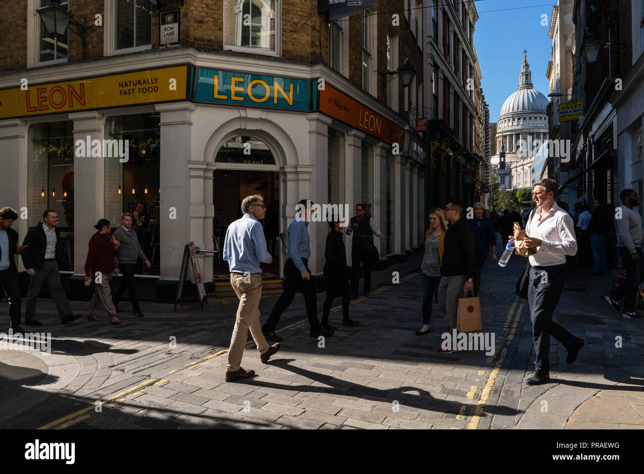 Scène de rue général des travailleurs de la ville de Londres s'occuper de leurs affaires pendant leur pause déjeuner près de la Cathédrale St Paul London UK Banque D'Images