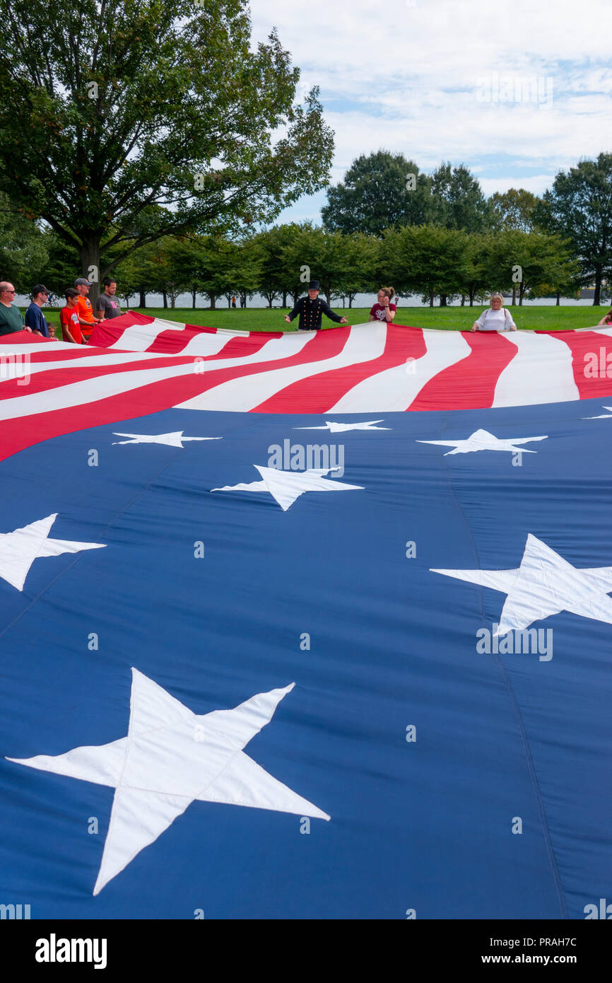 USA Maryland MD Baltimore Fort McHenry visiteurs tenir une grande réplique du drapeau qui était aux commandes Lorsque Francis Scott Key a écrit l'hymne poème Banque D'Images