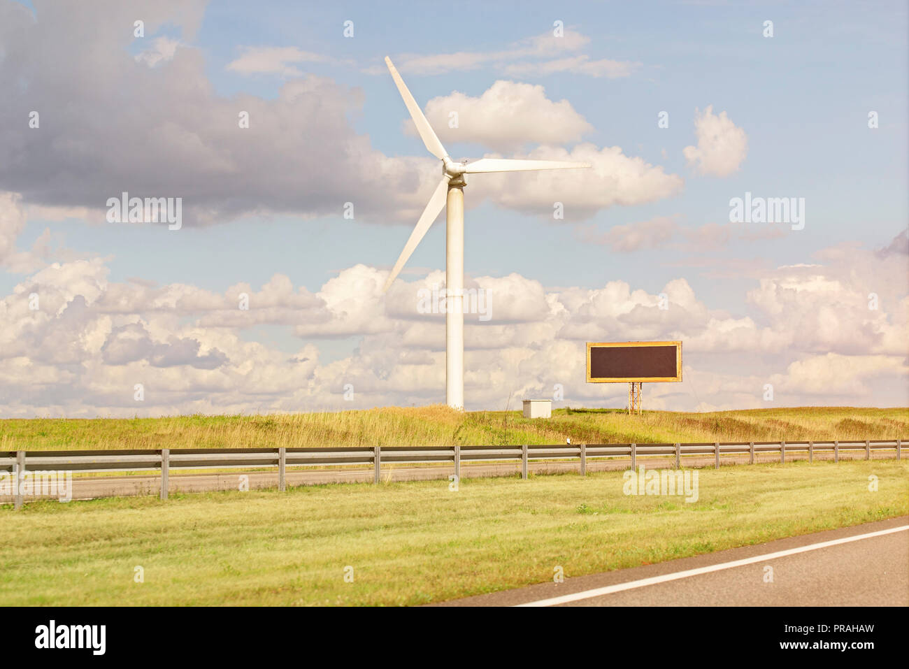 Moulin à vent et billboardin dans le champ près de la route. Banque D'Images