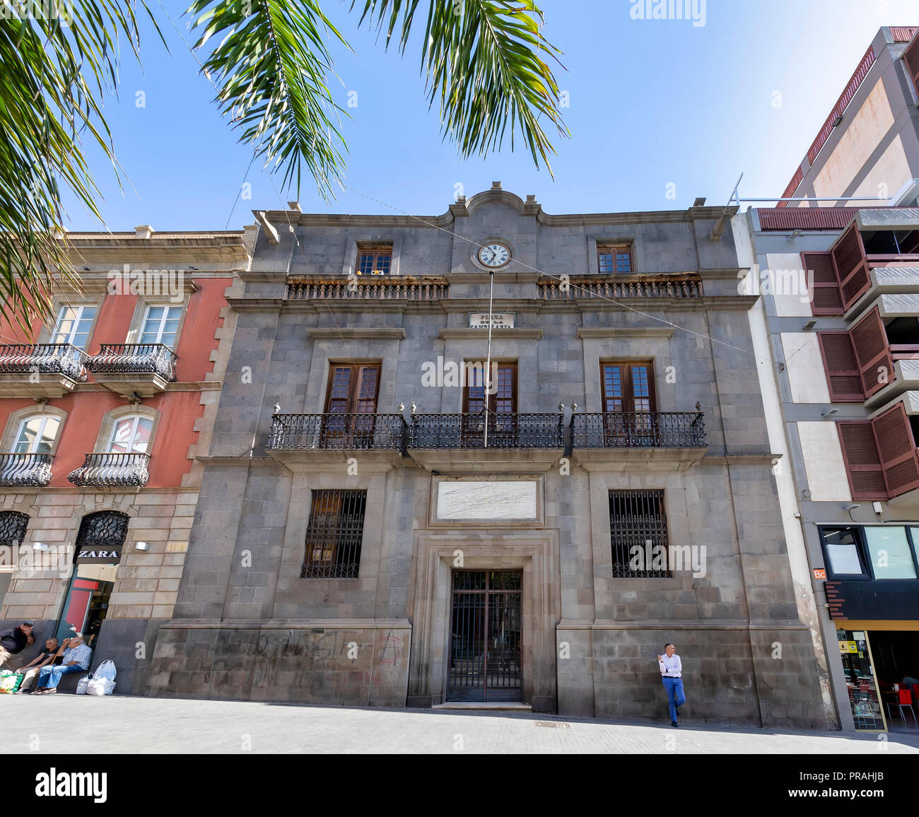 TENERIFE, ESPAGNE - 20 août : (NOTE DE LA RÉDACTION : un filtre polarisant a été utilisé pour cette image.) Un homme s'appuie contre le mur de l'hôtel Palacio de Carta (Carta Palace) à la Plaza de la Candelaria square à Santa Cruz de Tenerife le 20 août 2018 à Tenerife, Espagne. Le bâtiment a accueilli le Capitaine général des îles Canaries. Banque D'Images