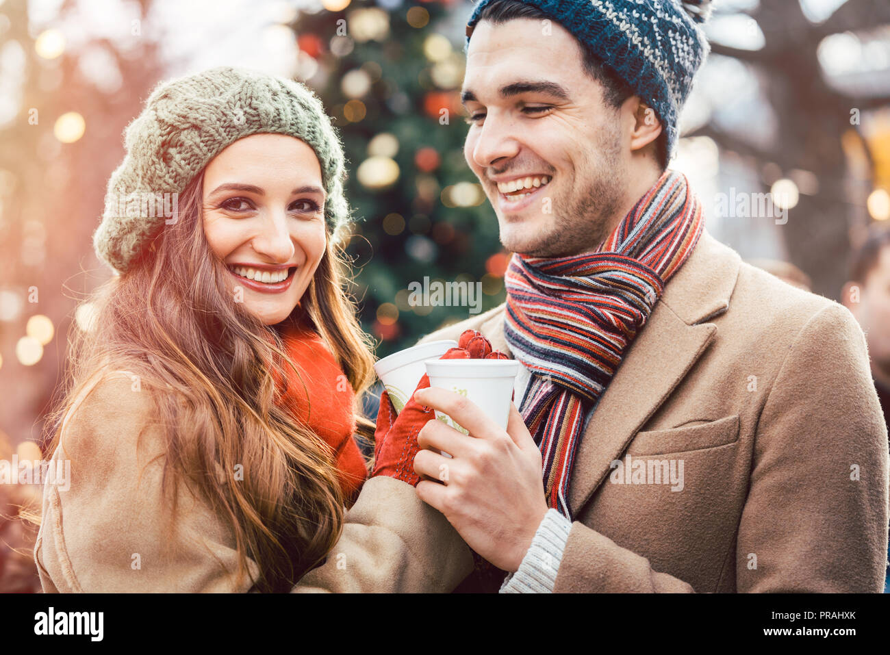 La femme et l'homme de boire du vin chaud sur le marché de Noël Banque D'Images