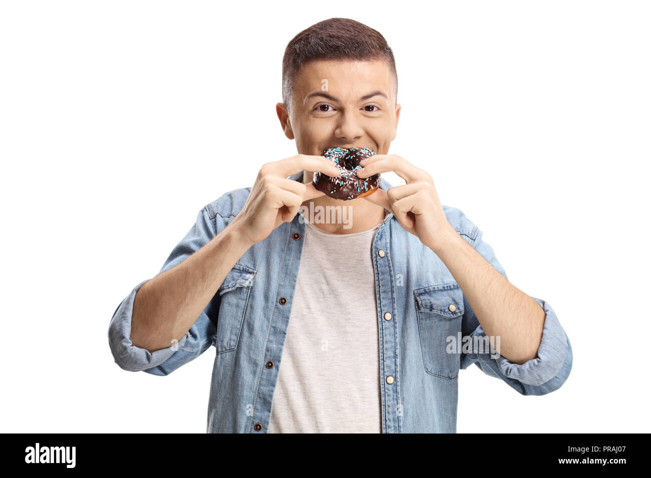 Teenage boy eating a chocolate donut isolé sur fond blanc Banque D'Images