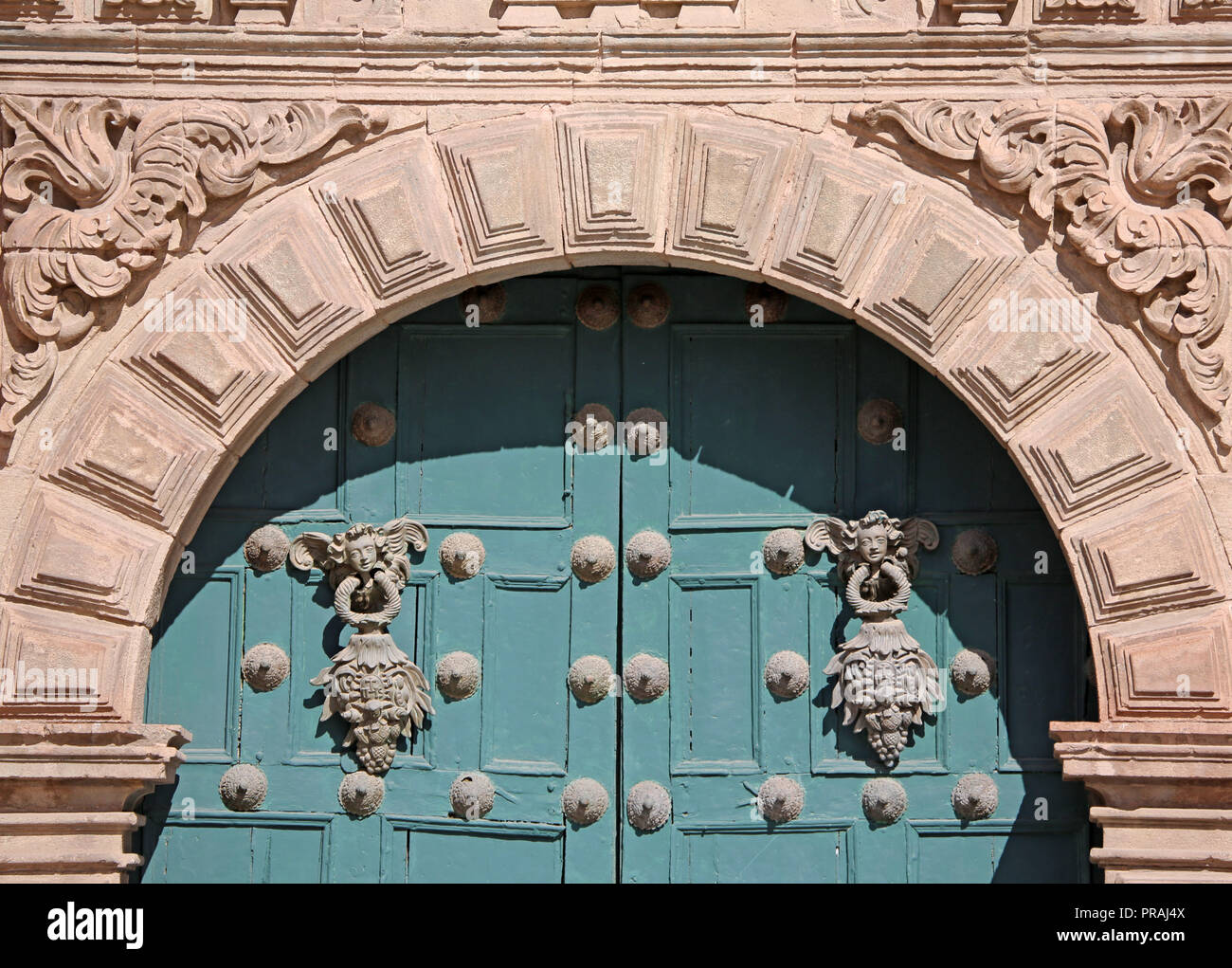 Détail de la pierre ouvragée porte bloc porte en bois vert et de manière décorative en métal avec, à l'église de la Compagnie de Jésus Banque D'Images