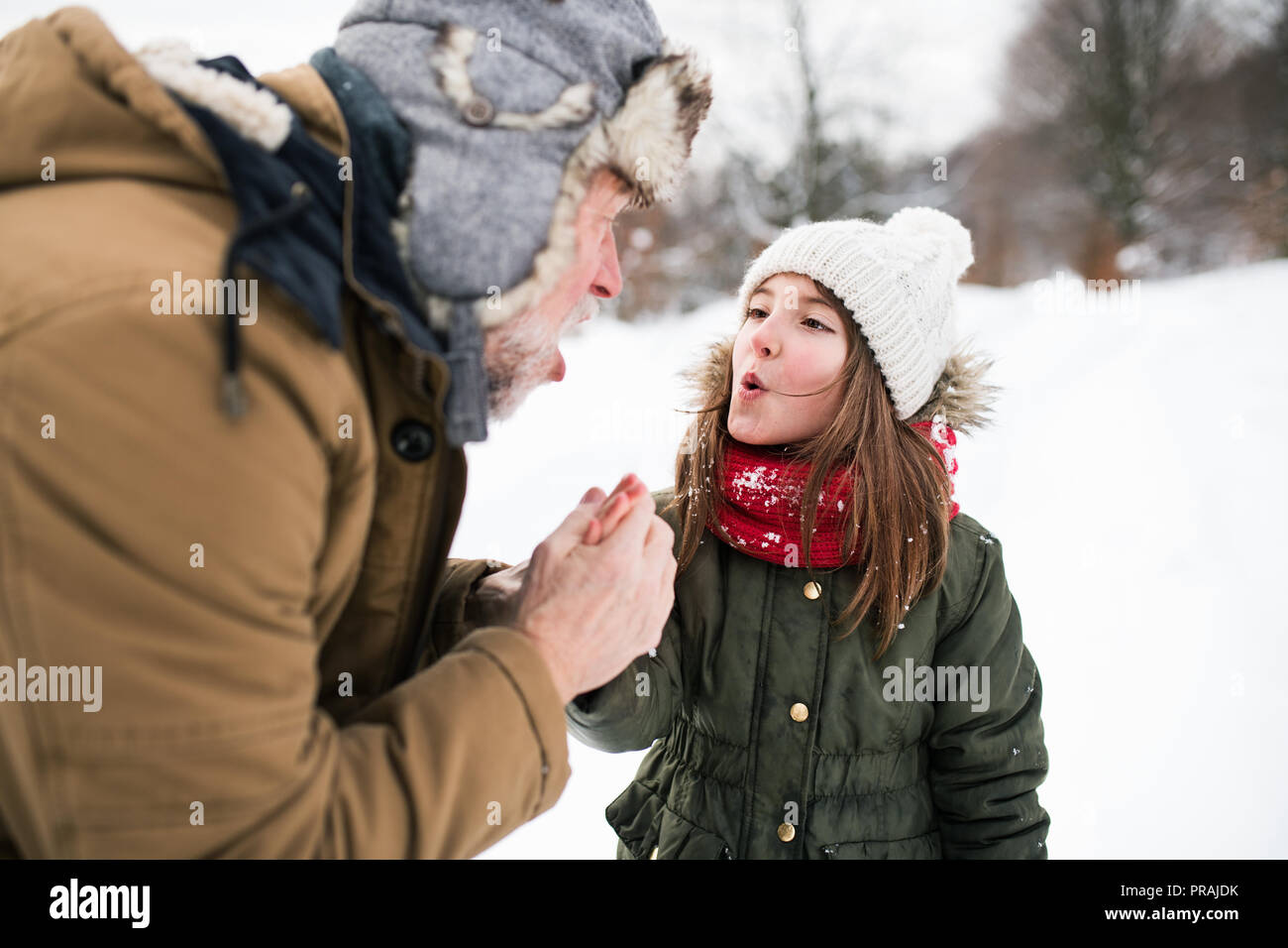 Grand-père et la petite fille dans la neige sur une journée d'hiver. Banque D'Images