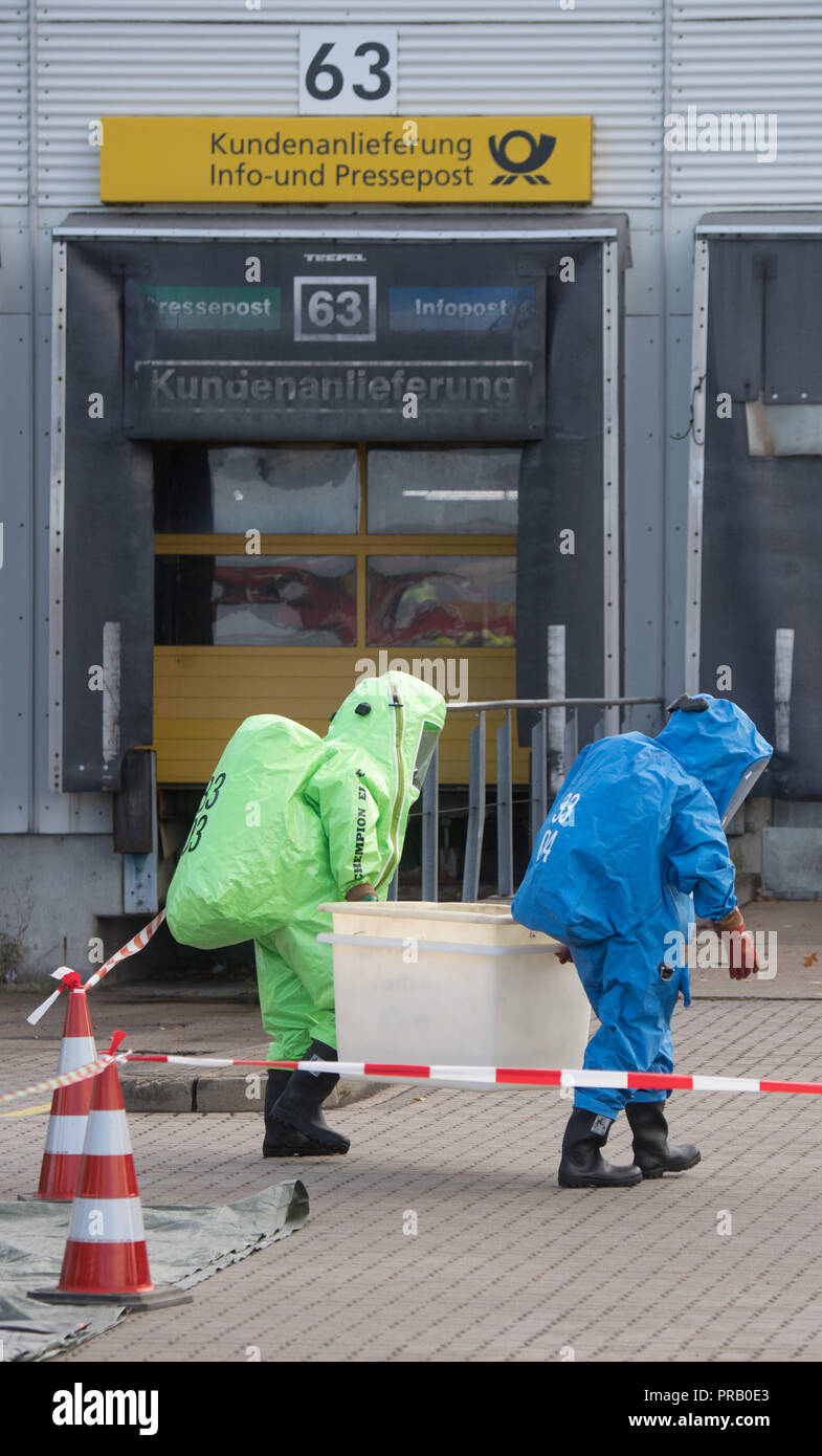 Pattensen, Allemagne. Le 01 octobre 2018. Les pompiers dans les scaphandres examiner une parcelle pendant une opération de matières dangereuses dans un colis et lettre centre de la Deutsche Post. Une fuite de liquide inconnu dans le centre de paquets a causé un incendie de grande ampleur l'opération de la brigade dans la matinée. Photo : Julian Stratenschulte/dpa dpa : Crédit photo alliance/Alamy Live News Banque D'Images