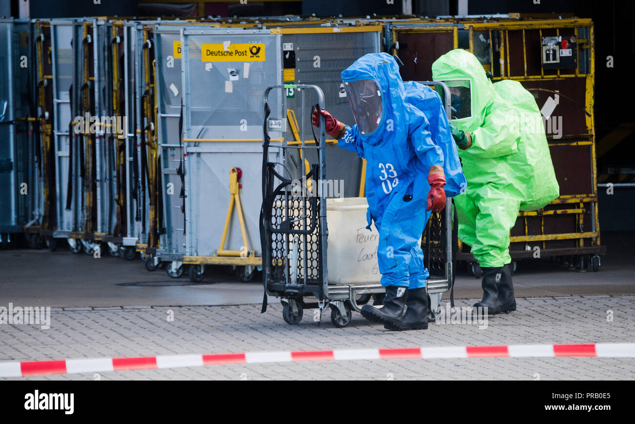 Pattensen, Allemagne. Le 01 octobre 2018. Les pompiers dans les scaphandres examiner une parcelle pendant une opération de matières dangereuses dans un colis et lettre centre de la Deutsche Post. Une fuite de liquide inconnu dans le centre de paquets a causé un incendie de grande ampleur l'opération de la brigade dans la matinée. Photo : Julian Stratenschulte/dpa dpa : Crédit photo alliance/Alamy Live News Banque D'Images