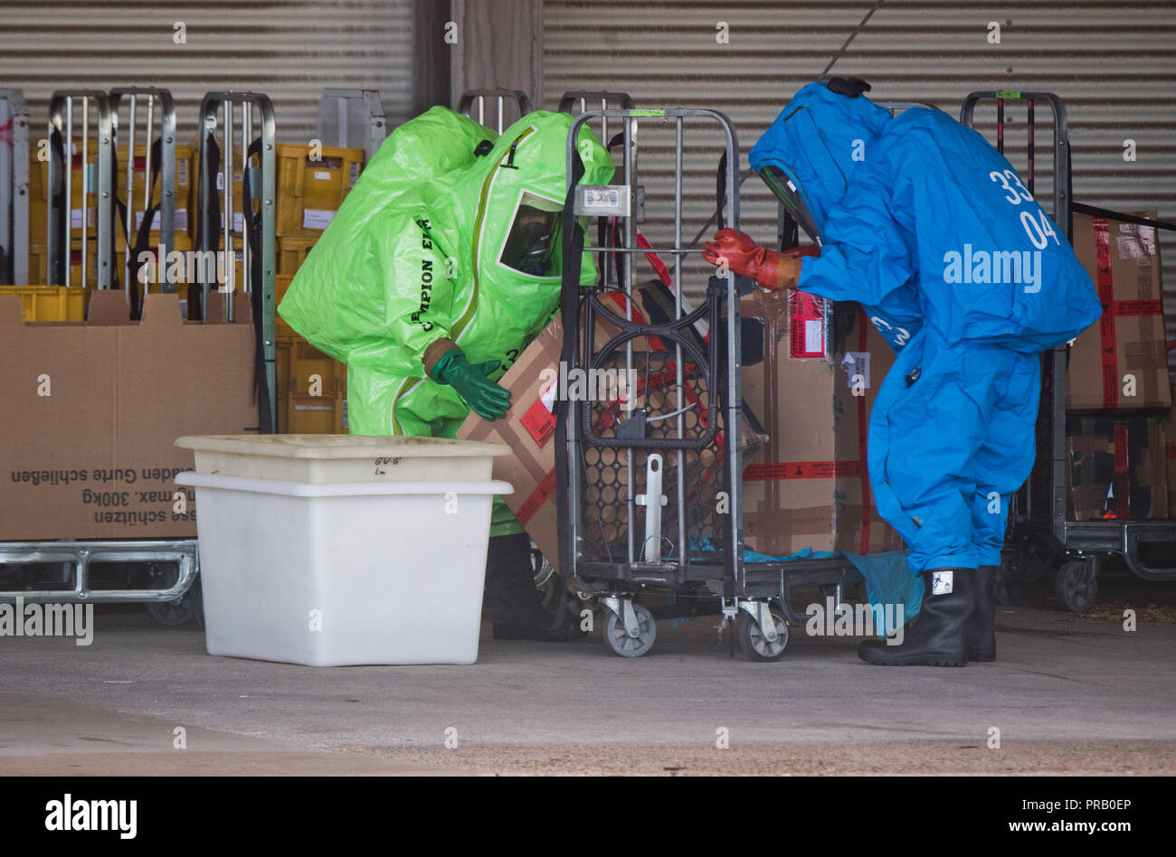 Pattensen, Allemagne. Le 01 octobre 2018. Les pompiers dans les scaphandres examiner une parcelle pendant une opération de matières dangereuses dans un colis et lettre centre de la Deutsche Post. Une fuite de liquide inconnu dans le centre de paquets a causé un incendie de grande ampleur l'opération de la brigade dans la matinée. Photo : Julian Stratenschulte/dpa dpa : Crédit photo alliance/Alamy Live News Banque D'Images