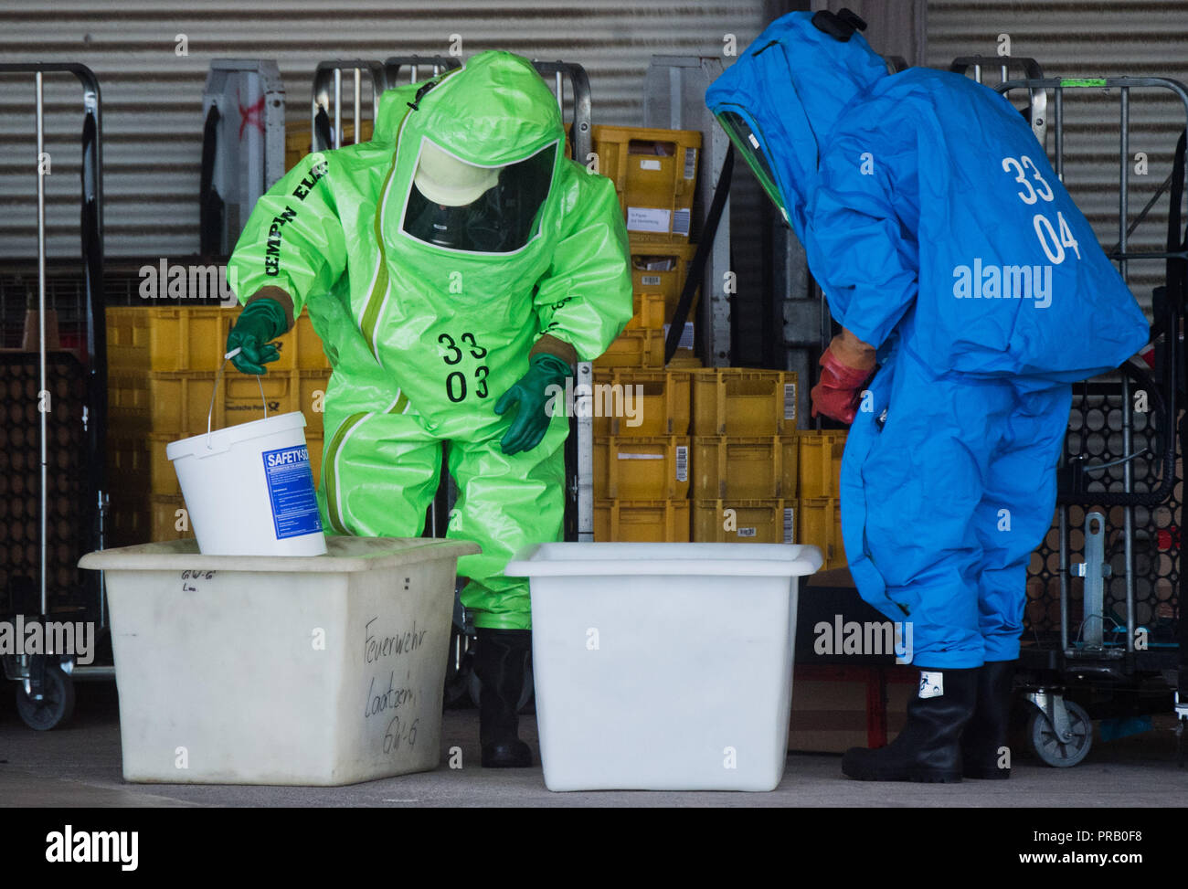 Pattensen, Allemagne. Le 01 octobre 2018. Les pompiers dans les scaphandres examiner une parcelle pendant une opération de matières dangereuses dans un colis et lettre centre de la Deutsche Post. Une fuite de liquide inconnu dans le centre de paquets a causé un incendie de grande ampleur l'opération de la brigade dans la matinée. Photo : Julian Stratenschulte/dpa dpa : Crédit photo alliance/Alamy Live News Banque D'Images