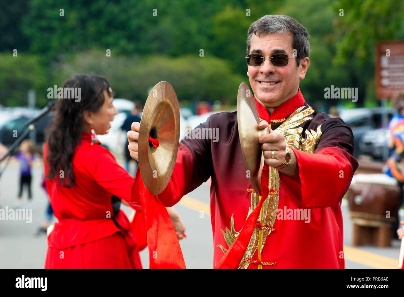 Une taille de l'équipe chinoise du tambour, vêtus de couleurs vives en costume traditionnel, fonctionne à un festival local. Banque D'Images