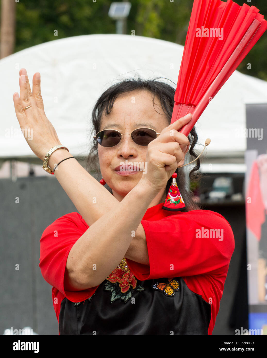 Une taille de l'équipe chinoise du tambour, vêtus de couleurs vives en costume traditionnel, fonctionne à un festival local. Banque D'Images