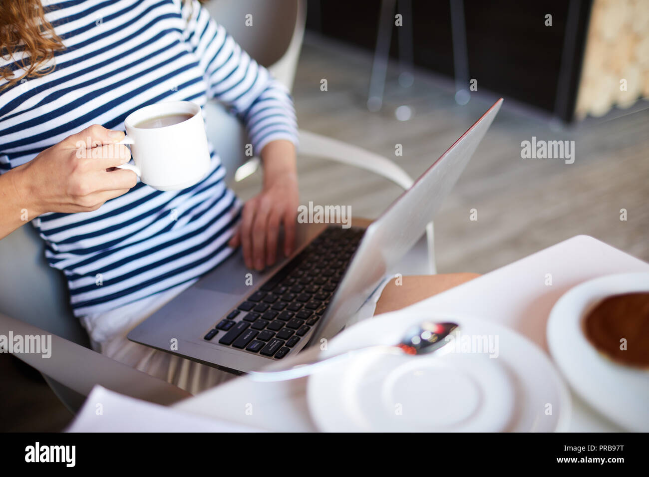 Close-up of woman in méconnaissable dépouillé de chandail de boire du café au café moderne avec connexion Wi-Fi gratuite Banque D'Images