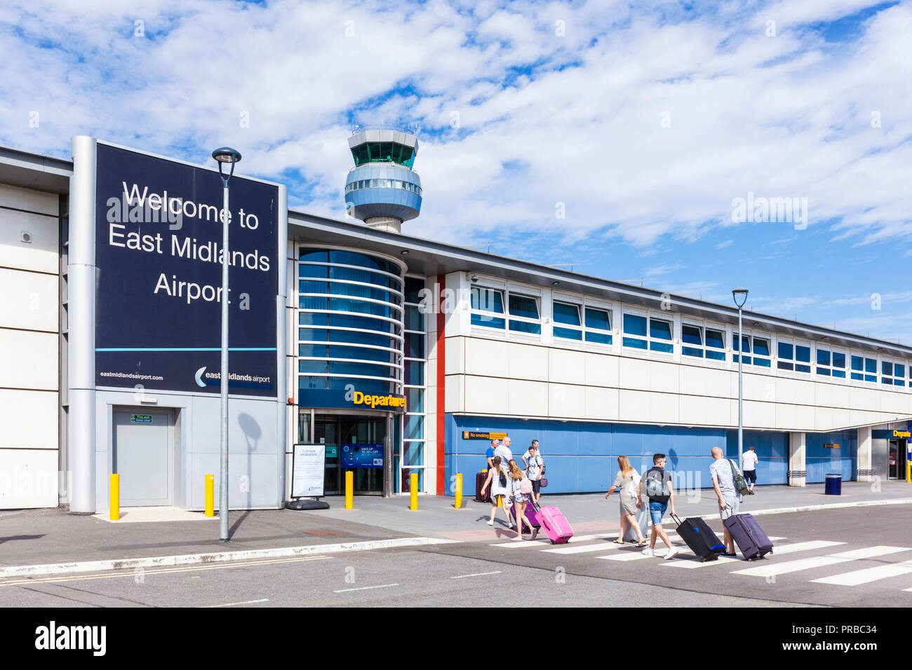 Les passagers de l'aéroport East Midlands en direction de l'entrée des départs de l'aéroport de East Midlands aérogare Castle Donnington Leicestershire UK Banque D'Images
