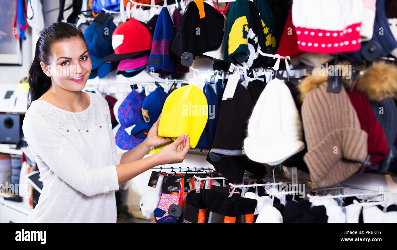 Femme adulte heureux en choisissant Nouveau knit cap dans magasin de sport Banque D'Images