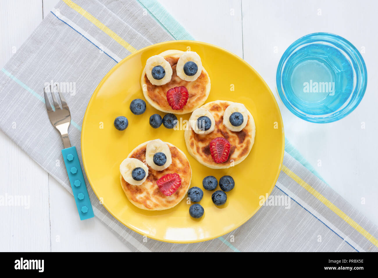 Petit-déjeuner de crêpes pour les enfants. Crêpes en forme animal mignon drôle sur une plaque jaune. Vue d'en haut. L'art de l'alimentation Banque D'Images