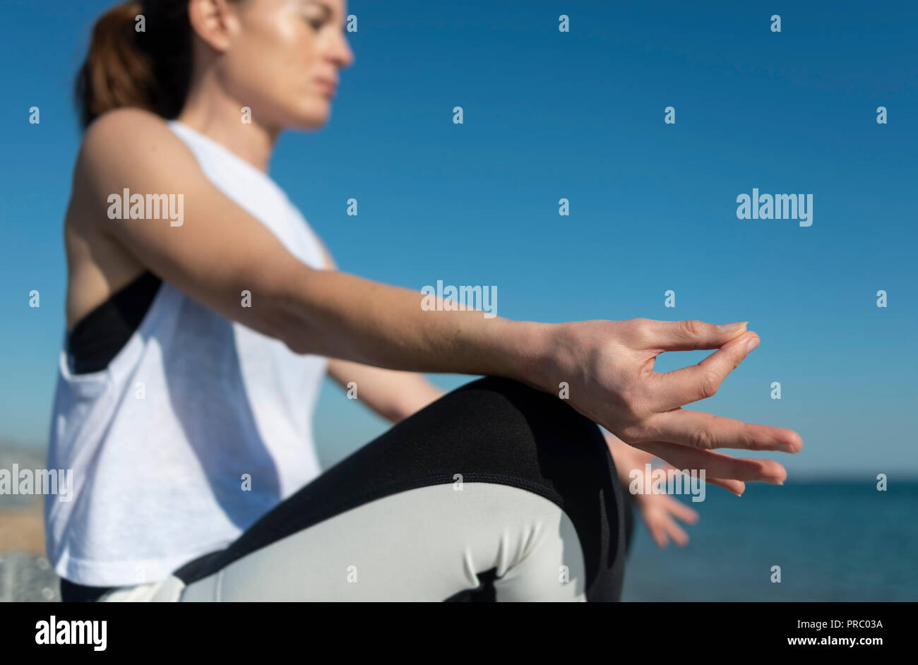 Femme méditant, pratiquant le yoga par la mer. Banque D'Images