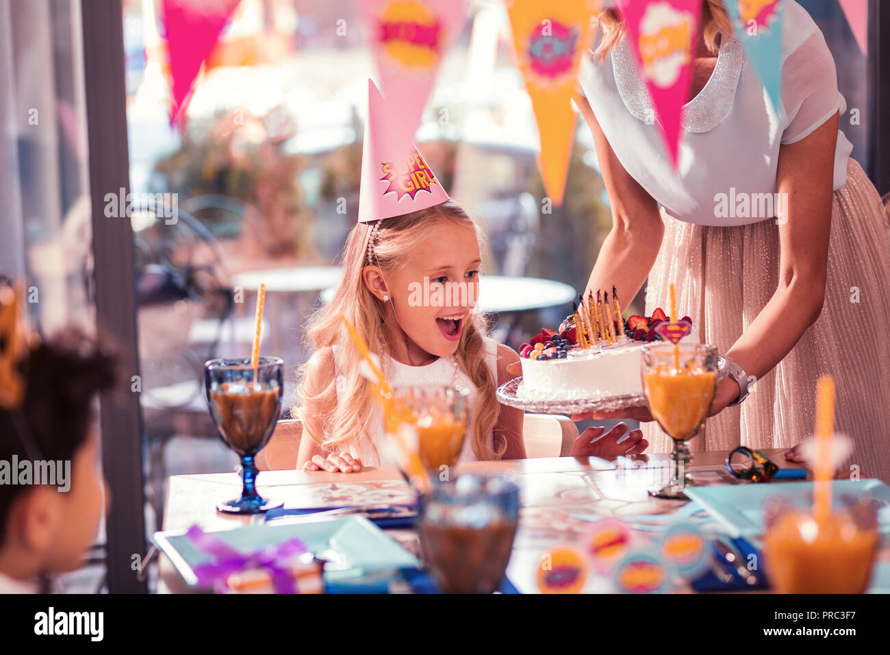 Fille émotionnelle sentiment heureux en regardant son gâteau d'anniversaire Banque D'Images
