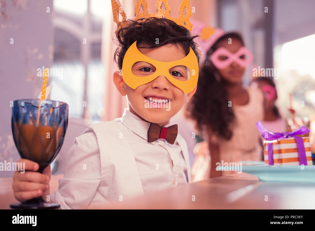 Smiling boy wearing mask Papier et verre de jus de portefeuille Banque D'Images
