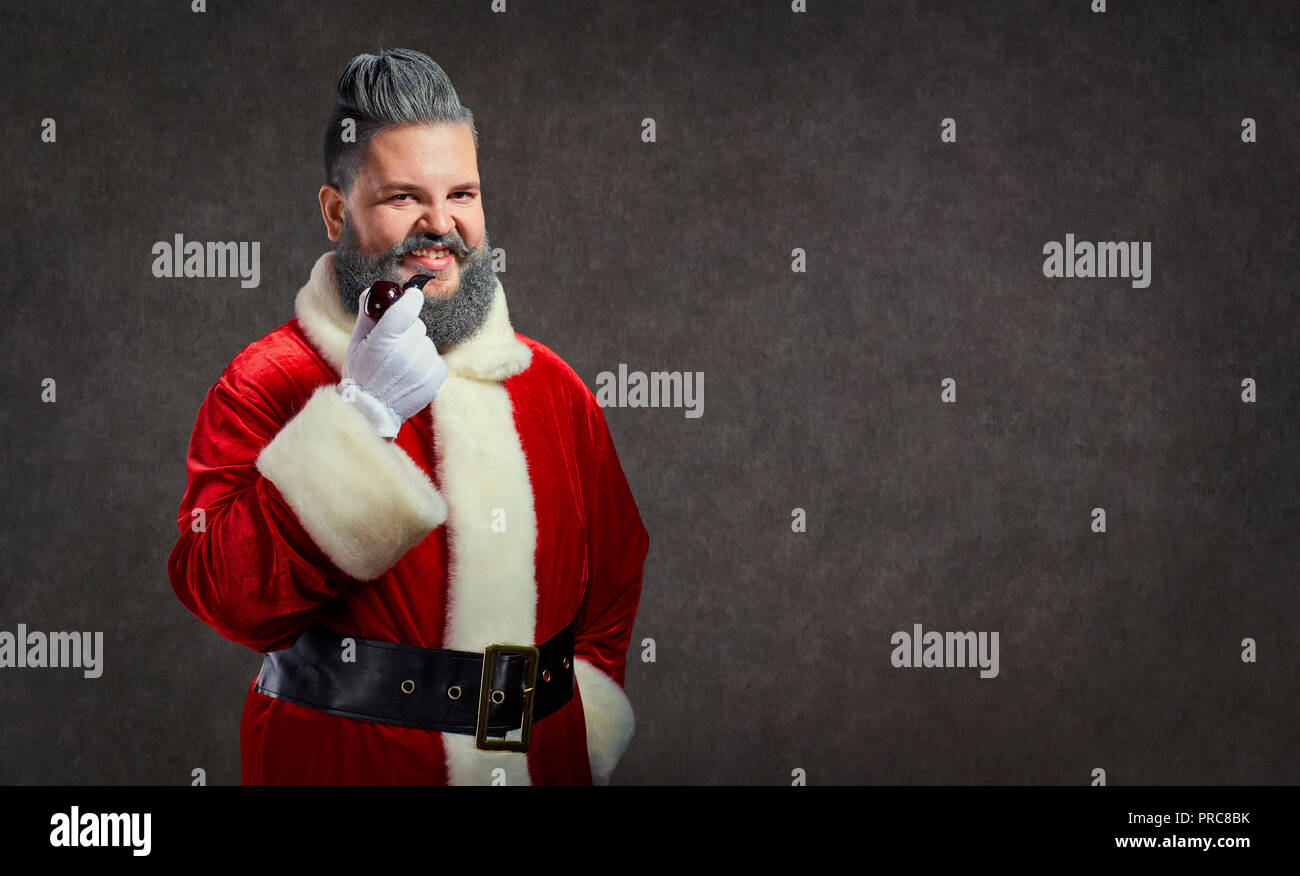Père Noël avec une coiffure et une fumée de cigare lance un joyeux Banque D'Images