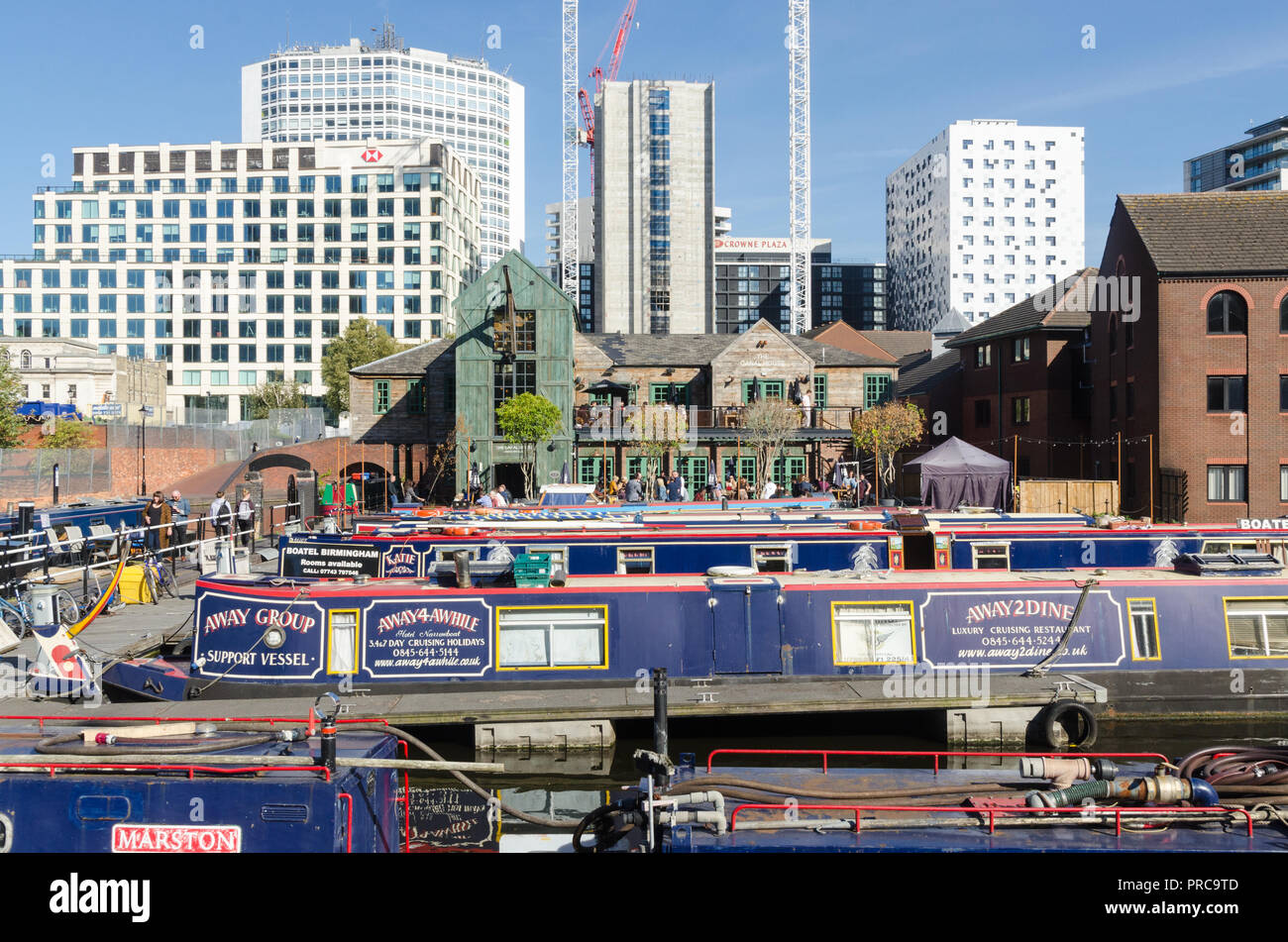 Étroites colorées des bateaux amarrés dans le bassin de gas Street au coeur de Birmingham's canal réseau avec le Canal House pub en arrière-plan Banque D'Images