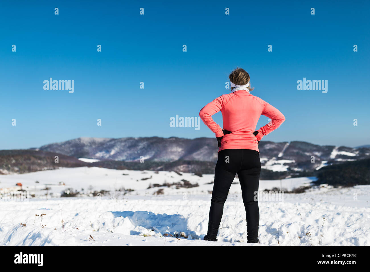 Vue arrière du senior woman runner reposant en hiver la nature. Banque D'Images