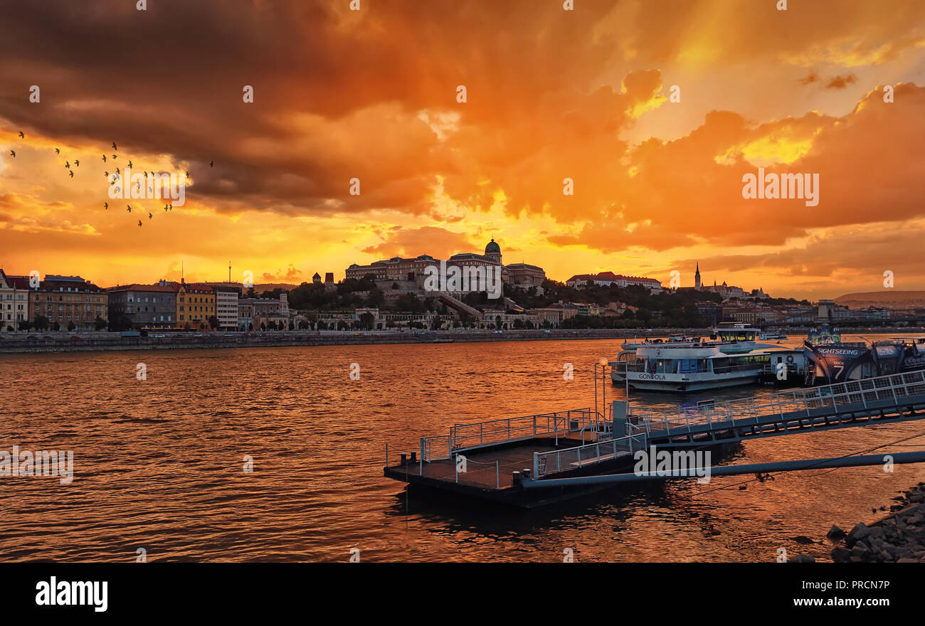 Vue sur la magnifique coucher de soleil sur le Danube, la colline de Buda et le Palais Royal du côté de Pest. Banque D'Images