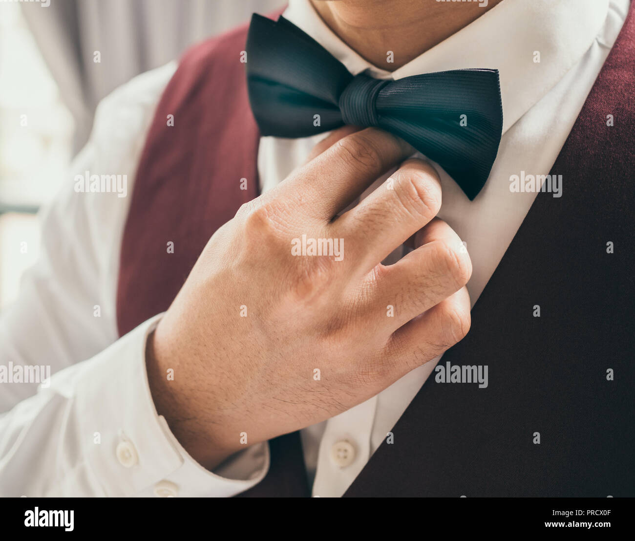 Close-up représentant part redresser noeud papillon noir sur blanc chemise  propre avec gilet rouge ou bordeaux Photo Stock - Alamy