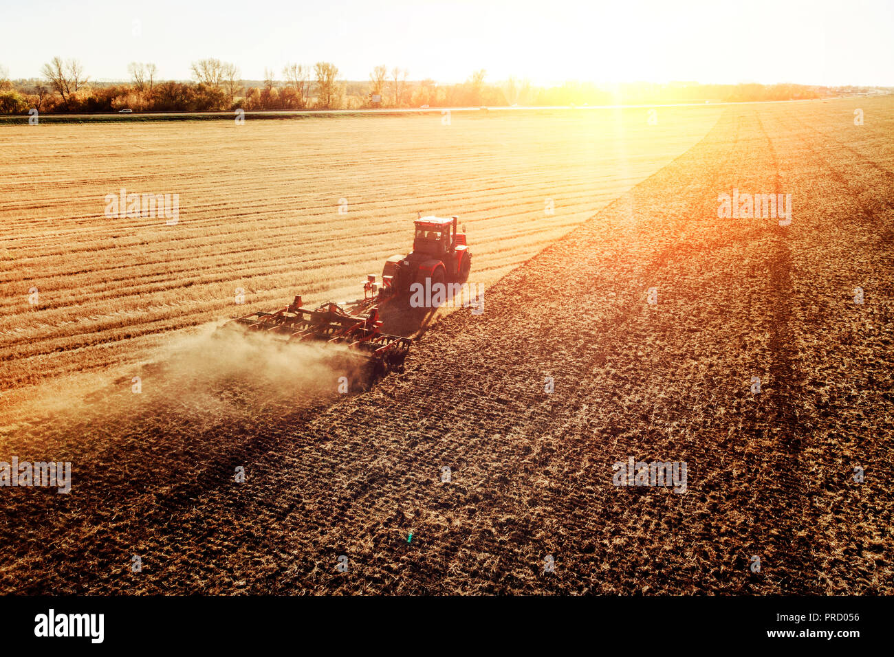Machine agricole la récolte dans les champs. Le tracteur tire sur un mécanisme pour la fenaison. La récolte en automne le matin à l'aube. de l'agrobusiness en t Banque D'Images