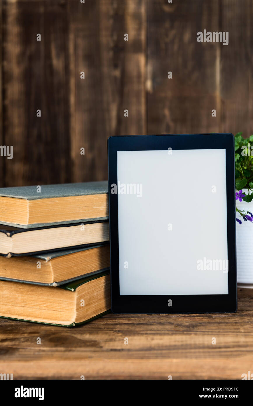 Ebook, tablette numérique, avec de vieux livres réel sur le fond rustique à proximité Banque D'Images