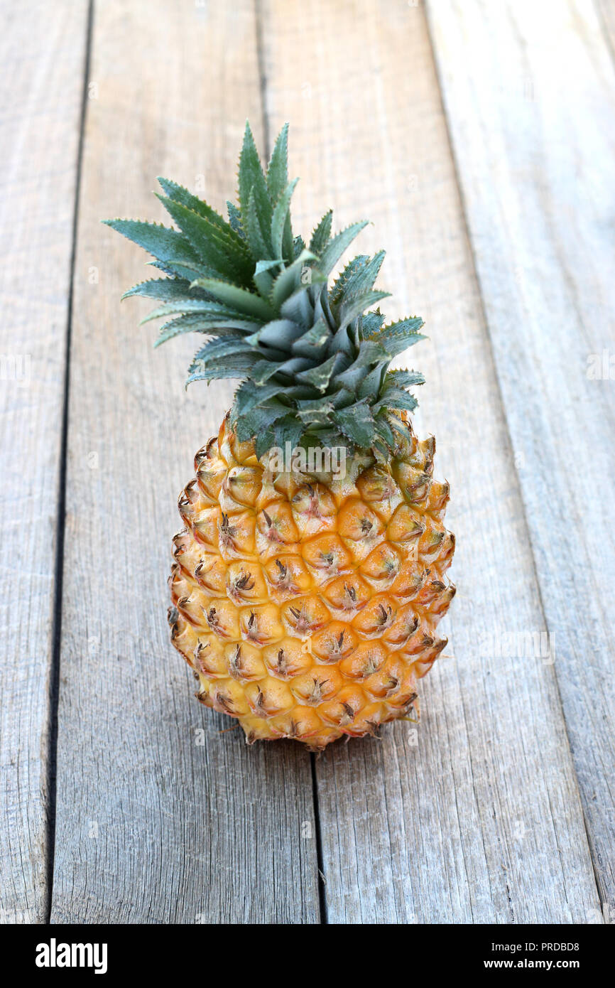 Close up de l'ensemble de l'ananas isolé sur fond de bois Banque D'Images