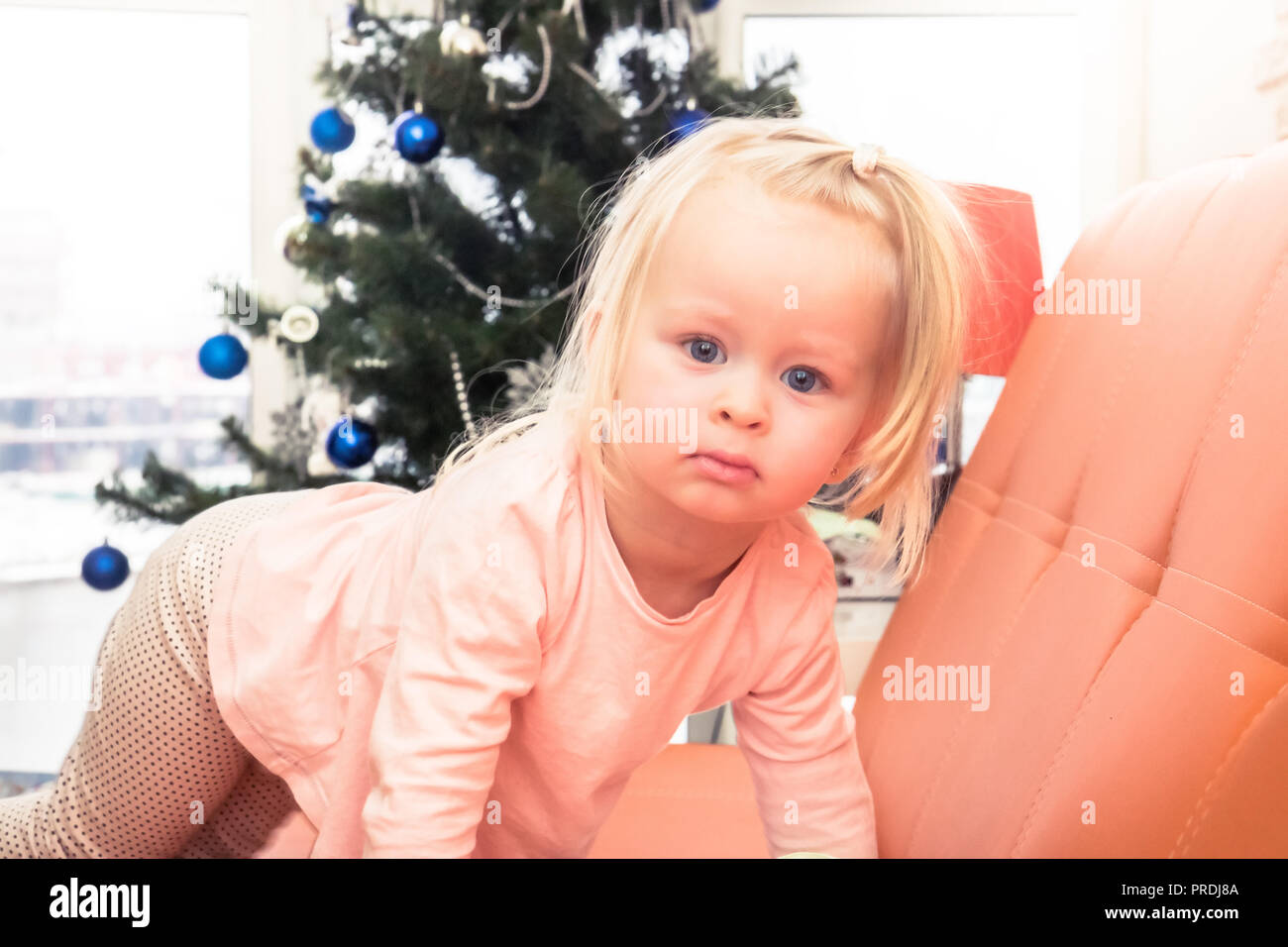 Glamour Noël cute baby girl portrait avec arbre de Noël à la maison d'arrière-plan Banque D'Images