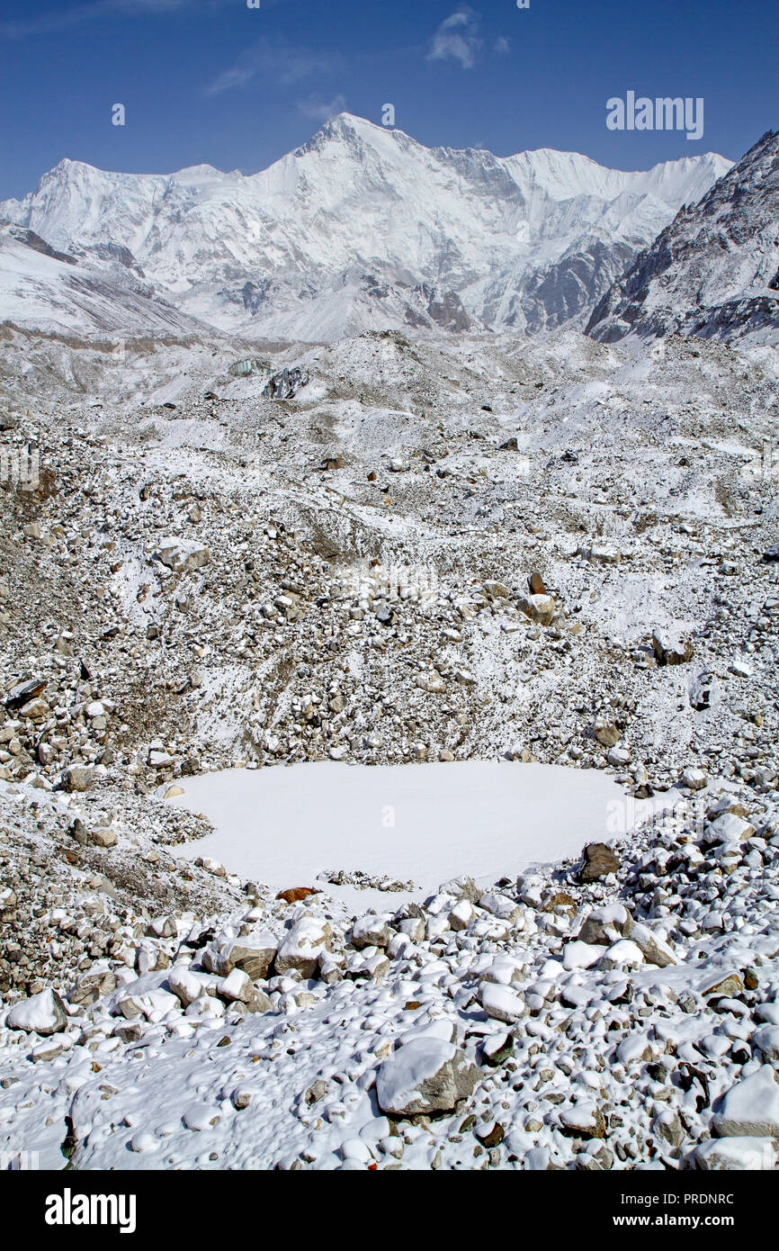 Mise en commun sur la surface du lac de glacier Ngozumpa, avec Cho Oyu au-delà Banque D'Images