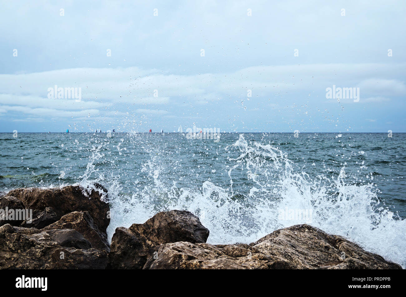 Dans l'arrière-plan il y a beaucoup de voiles colorées et lumineuses sur l'horizon de mer. Une grande éclaboussure d'eau et beaucoup de gouttes a décollé et a gelé dans le Banque D'Images