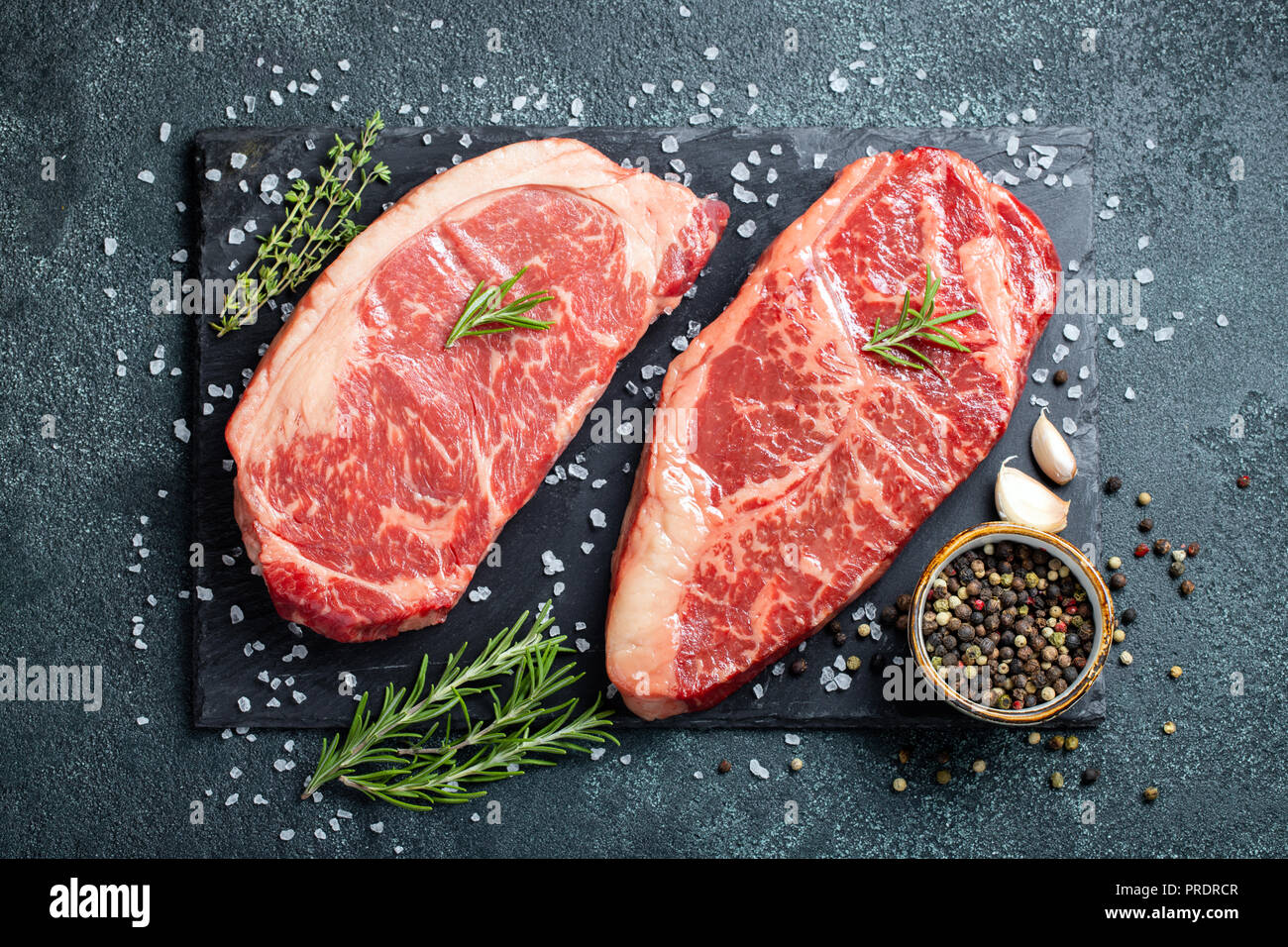 Premier exemple des steaks de boeuf Black Angus stone sur board : faux filet, faux-filet. Vue d'en haut. Sur un fond sombre Banque D'Images