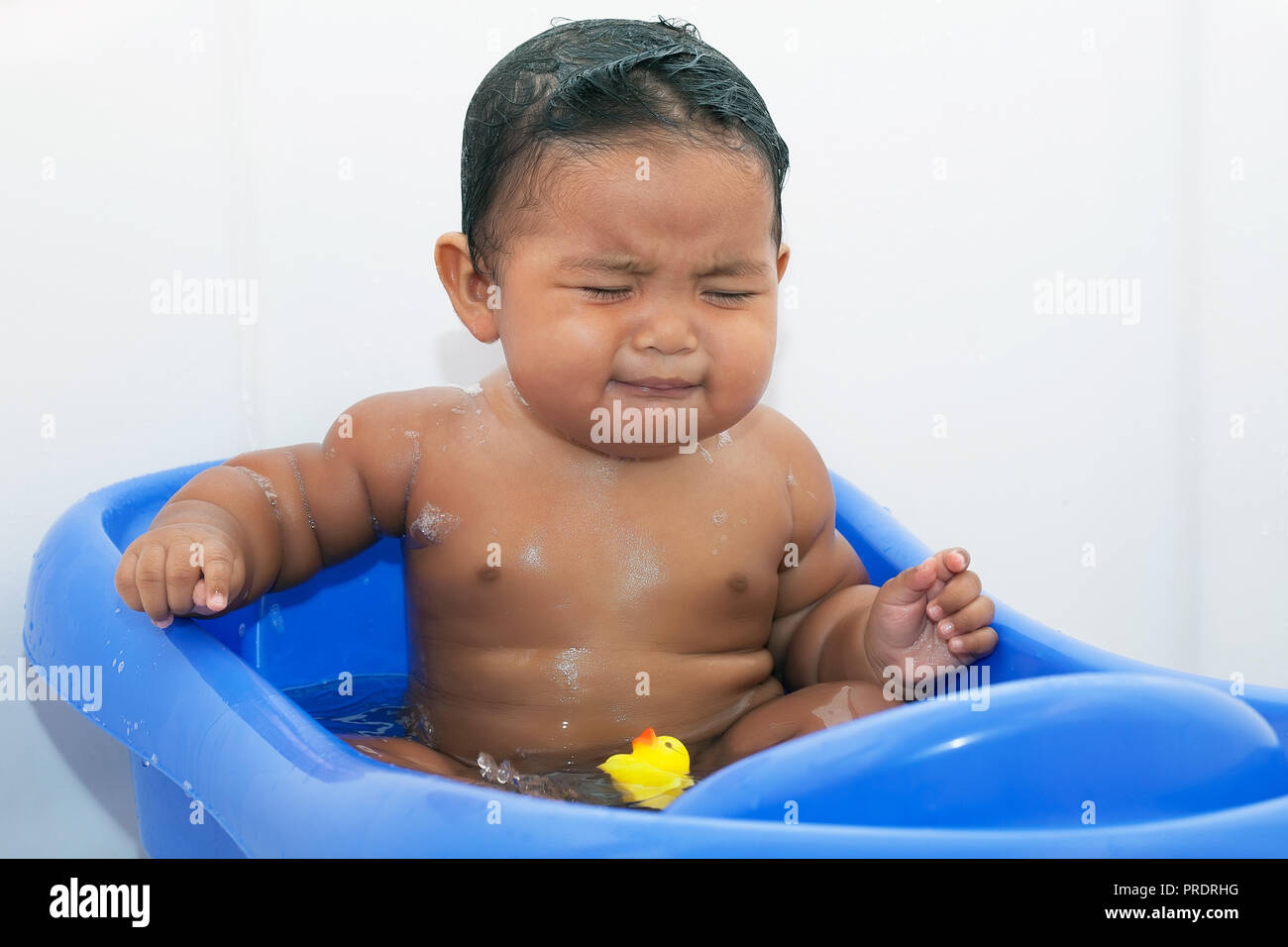 Bebe Joufflu Prendre Un Bain Dans Une Baignoire De Bebe Assis Dans L Eau Avec Du Savon Et De Pleurer A La Colere Photo Stock Alamy