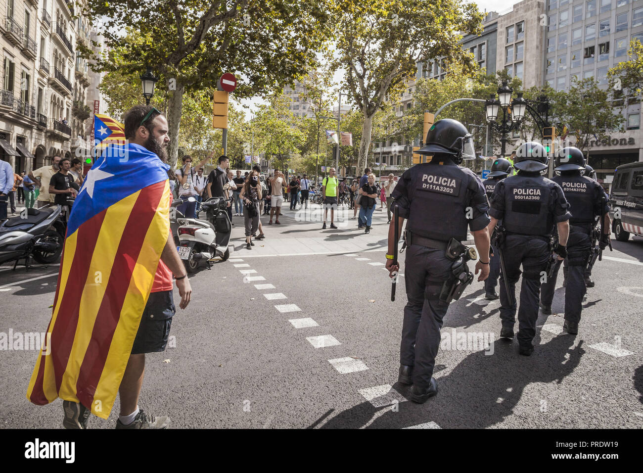 Barcelone, Catalogne, Espagne. 1 octobre, 2018. Avec drapeau indépendantiste catalan observe les policiers anti-émeute après une démonstration pendant le premier anniversaire de l'indépendance des élections catalanes en 2017. Credit : Celestino Arce Lavin/ZUMA/Alamy Fil Live News Banque D'Images
