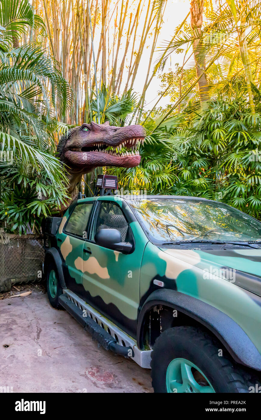 ORLANDO, FLORIDE, USA - DÉCEMBRE, 2017 : entre les buissons de dinosaures avec sa bouche ouverte montrant ses dents sur une voiture dans le parc à thème Universal Studios O Banque D'Images