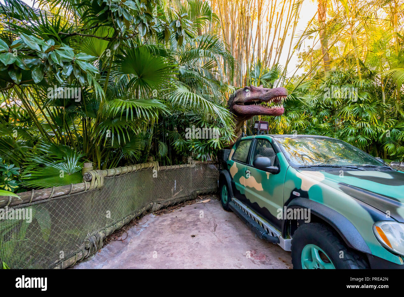 ORLANDO, FLORIDE, USA - DÉCEMBRE, 2017 : entre les buissons de dinosaures avec sa bouche ouverte montrant ses dents sur une voiture dans le parc à thème Universal Studios O Banque D'Images
