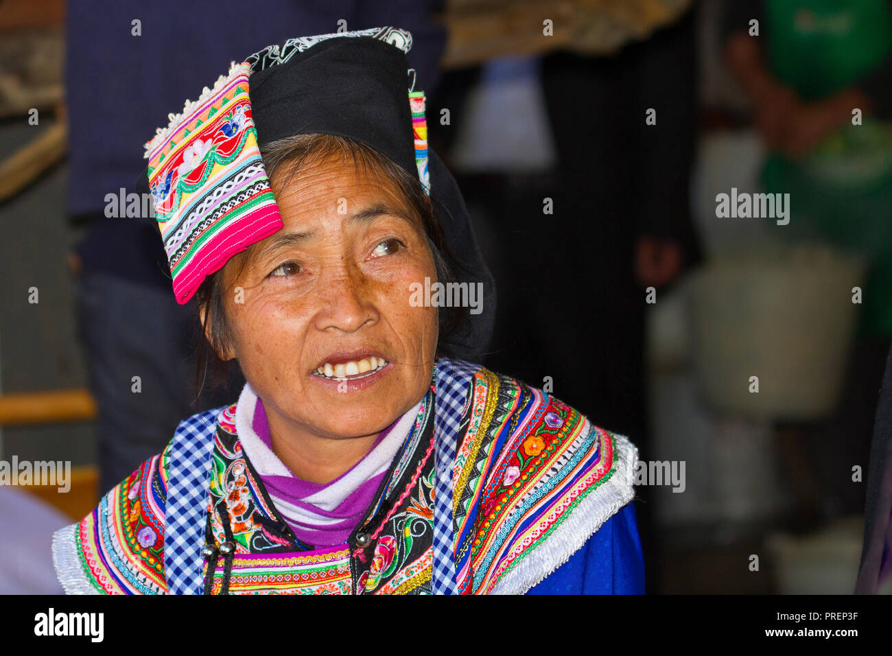Femme de l'Hani groupe ethnique minoritaire portant les vêtements colorés traditionnels au marché de Niujiaozhai rural town, dans la province du Yunnan Yuanyang, Banque D'Images