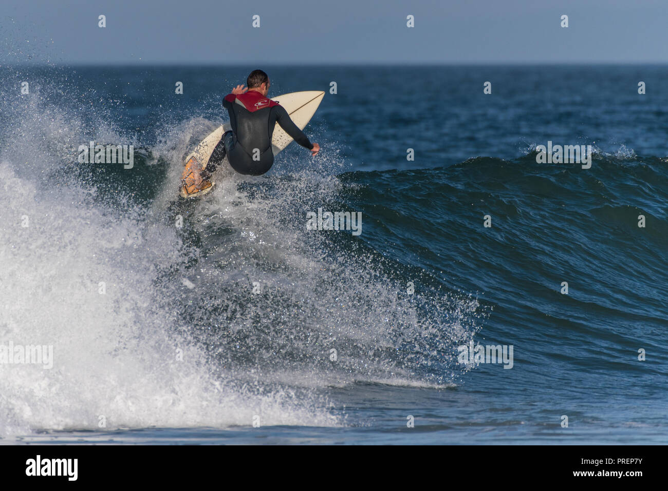 Surfer en combinaison isothermique complète hits la lèvre d'ondes à pleine vitesse à Surfer's Knoll, Ventura, Californie, le 1 octobre 2018. Banque D'Images