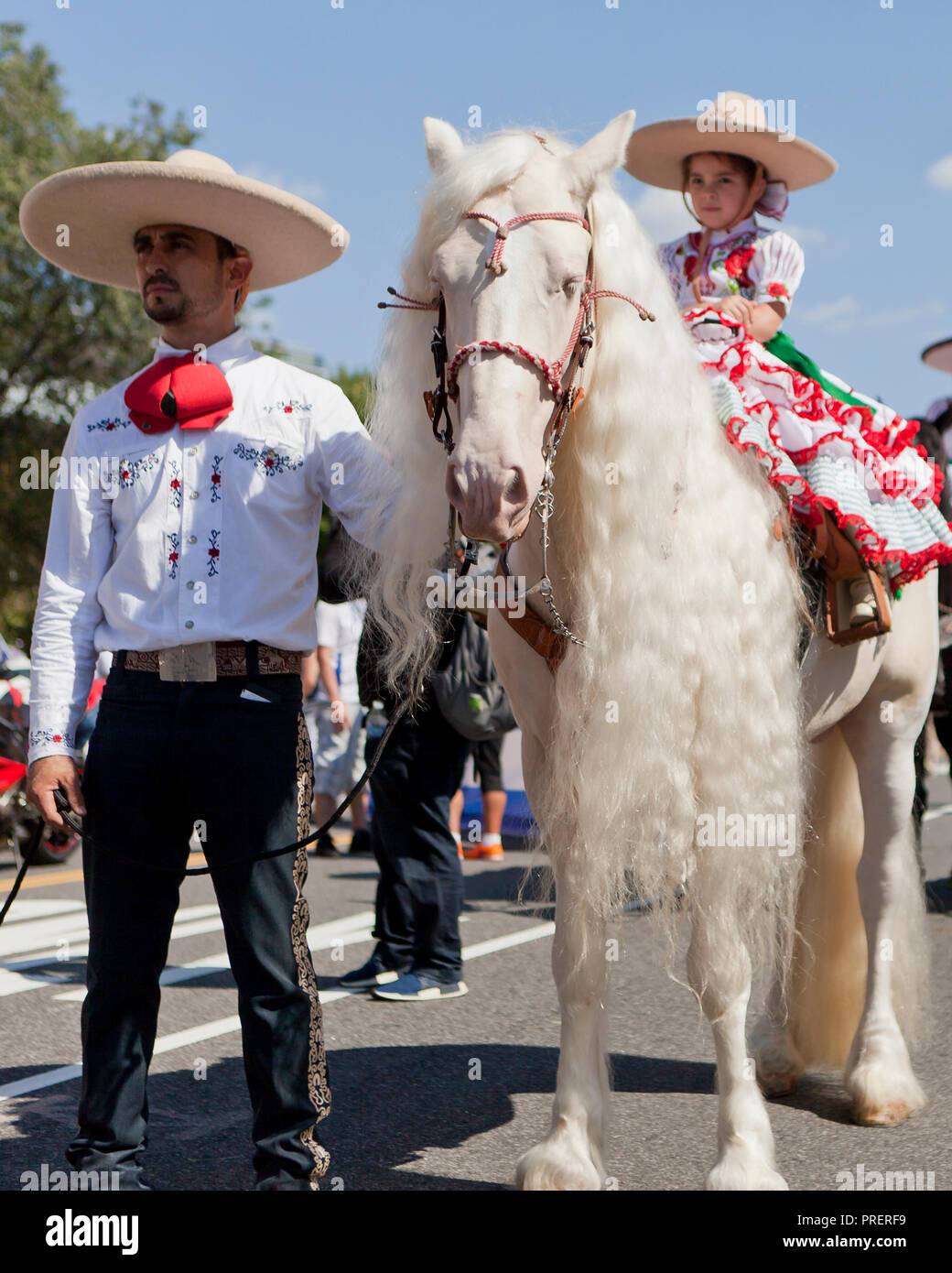 Cowgirl mexicain (charras) sur un Cremello cheval blanc (aka blue-eyed crème) avec les cheveux longs (long mane) - USA Banque D'Images
