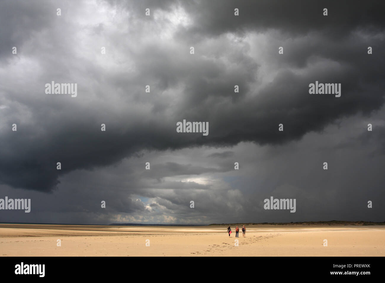 Storm clouds over Normandy Beach avec trois petites figures, Big Sky Banque D'Images