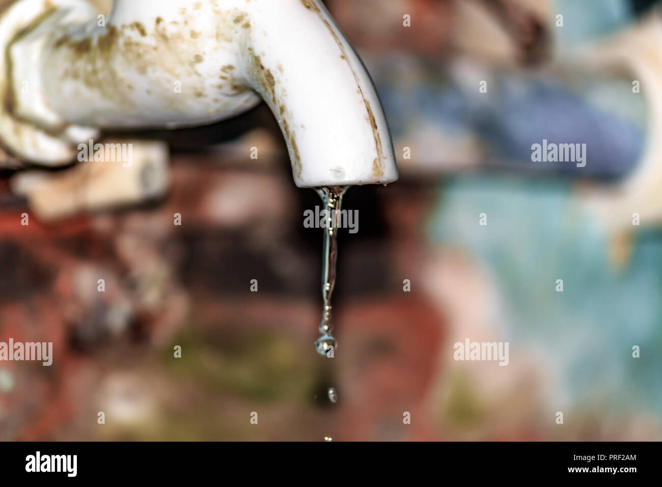 Fuite d'eau douce de l'ancien tuyau de plastique. Close up. Isolé de l'arrière-plan. La conservation de l'eau ménage Concept. Banque D'Images