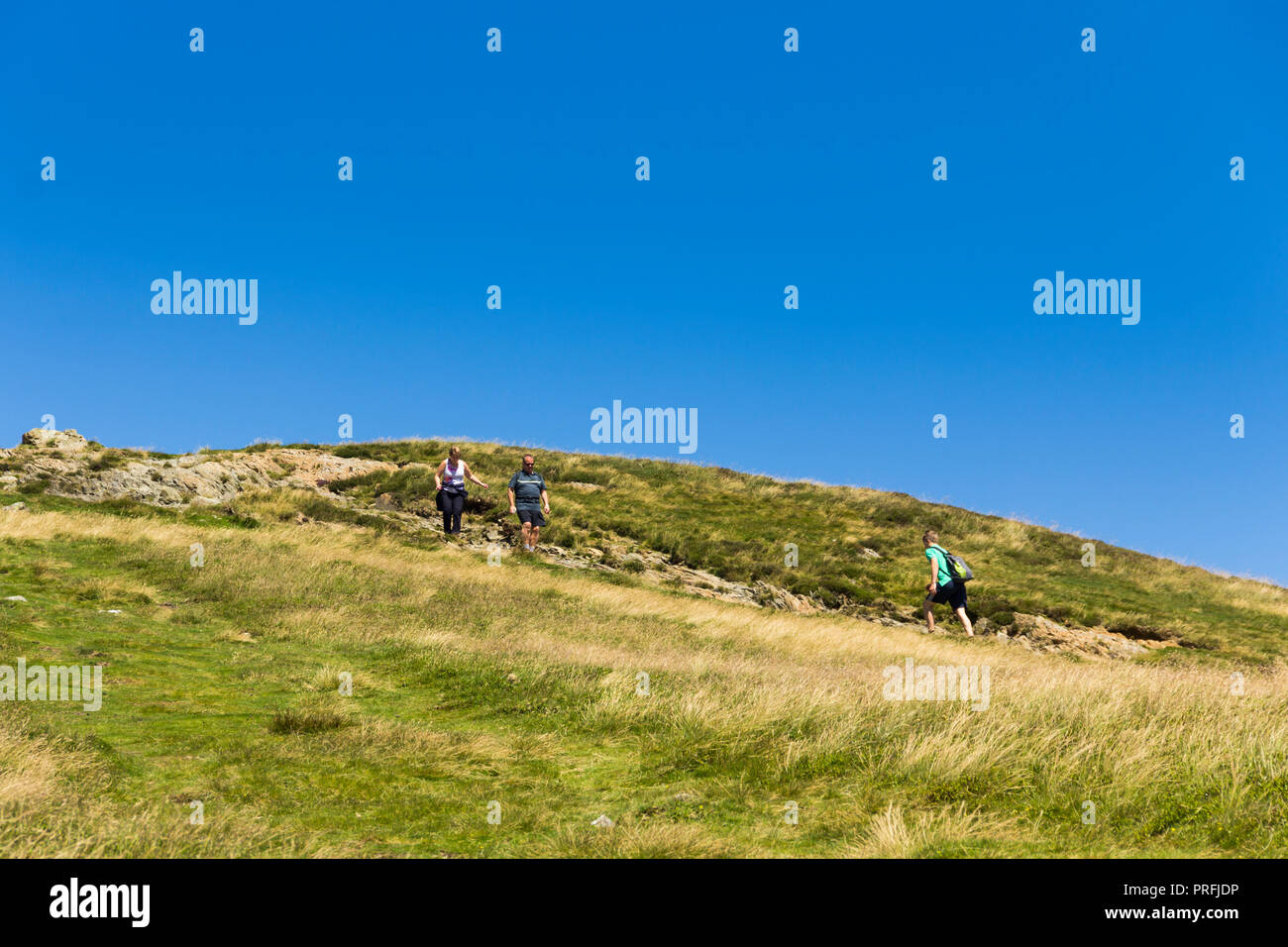 Trois promeneurs approchent l'un de l'autre sur le sentier menant au sud du sommet du Cat Bells (451 mètres) Près de Keswick, Cumbria. Banque D'Images